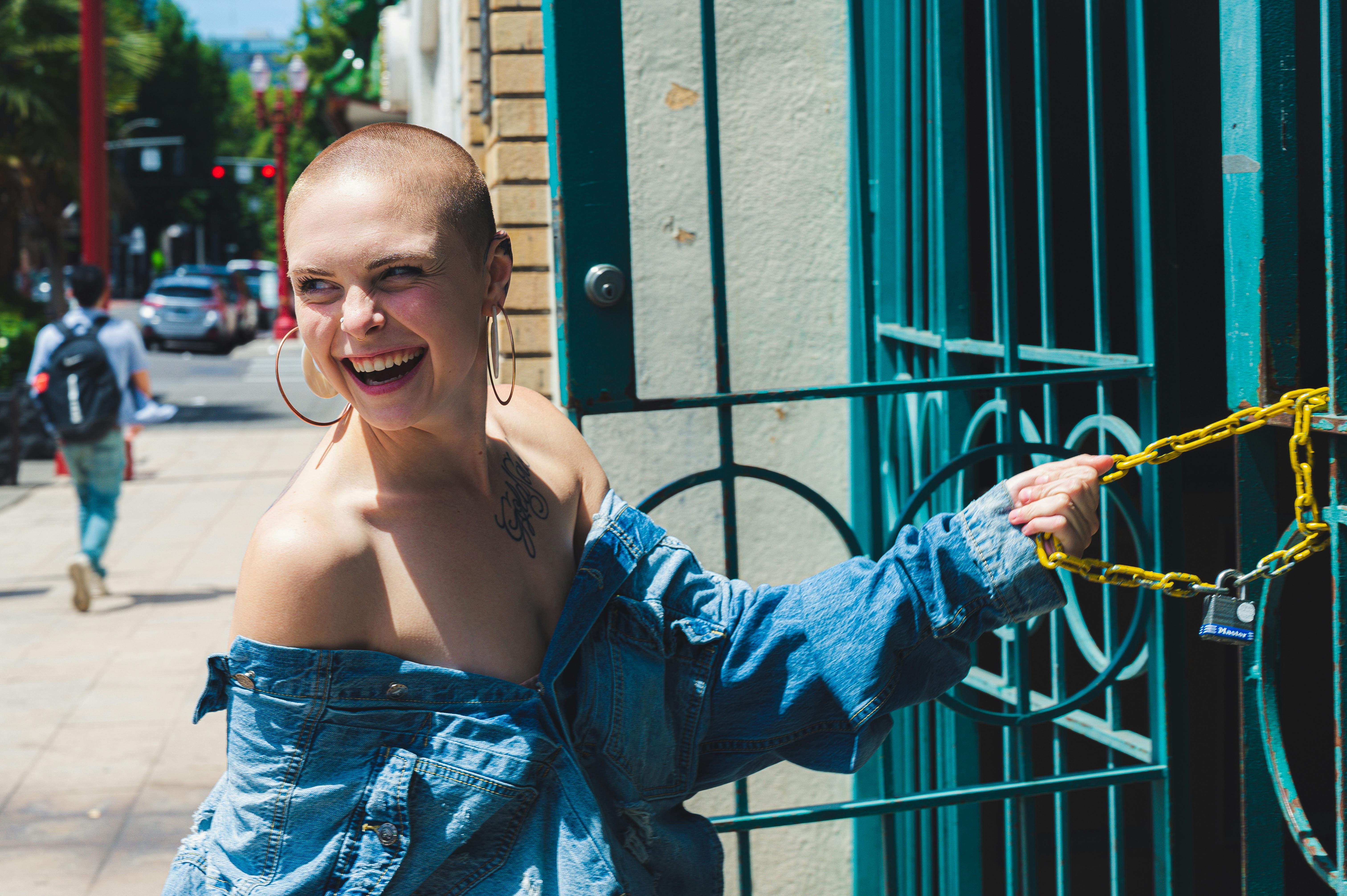 一位短发、穿着牛仔夹克的快乐女人，正在户外享受阳光明媚的一天