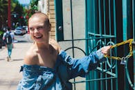 一位短发、穿着牛仔夹克的快乐女人，正在户外享受阳光明媚的一天