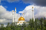 在充满活力的蓝天下，哈萨克斯坦阿斯塔纳一座金色圆顶的大清真寺呈现出壮丽景色