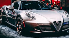 特写镜头下，一辆圆滑的金属银色跑车在室内展览中展示其豪华设计