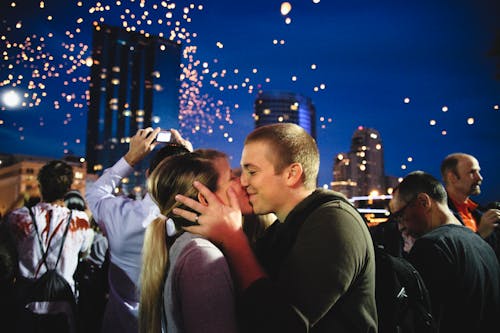 Free Photo of Couple Kissing Near Crowd Stock Photo