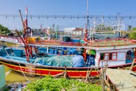 充满活力的传统渔船停靠在乡村港口，展示沿海生计和海上活动