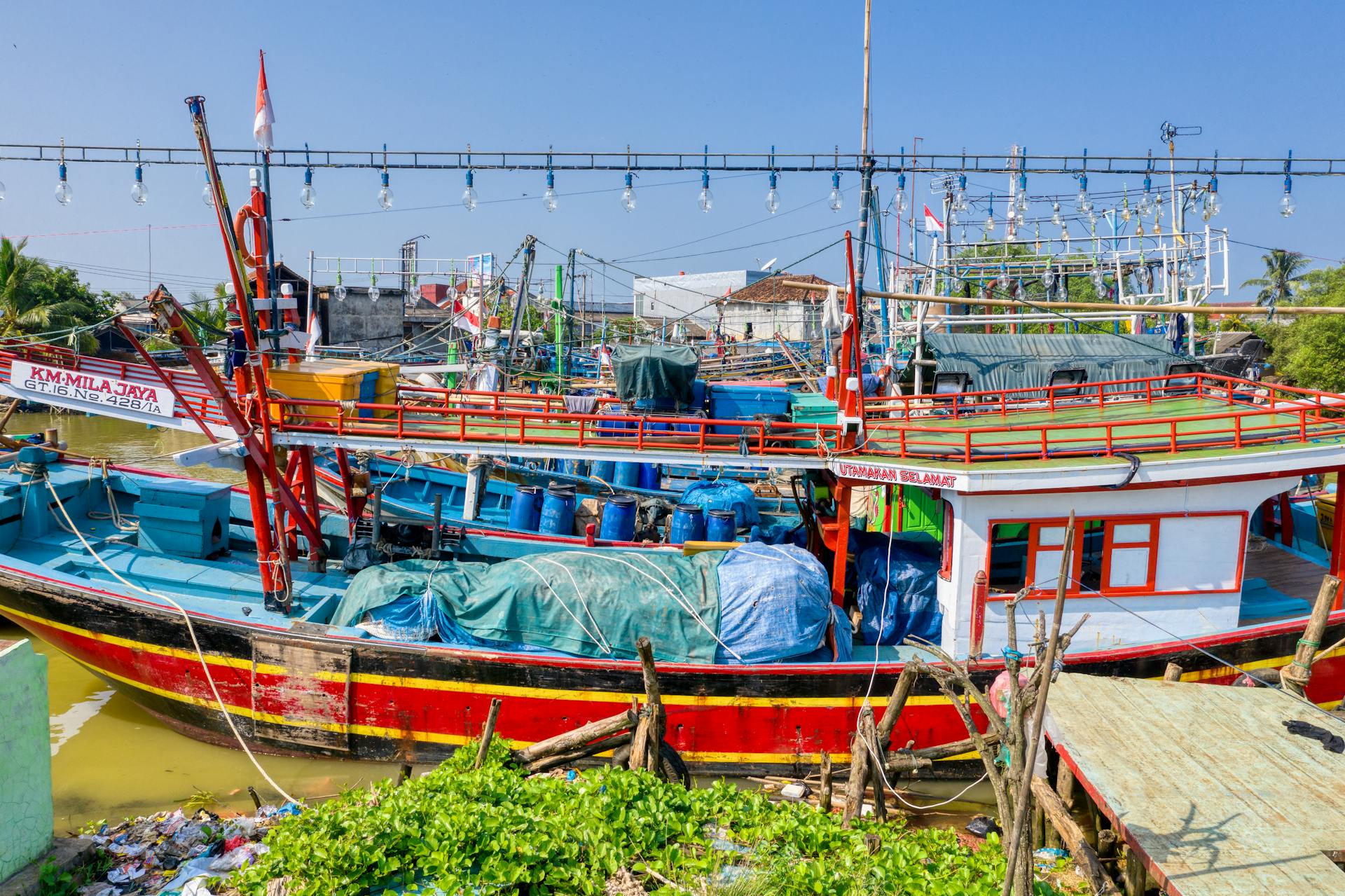 Vibrant traditional fishing boats docked in a rural harbor, showcasing coastal livelihood and maritime activities.