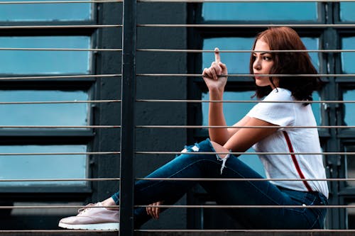 Photo of Woman Sitting Beside Railings