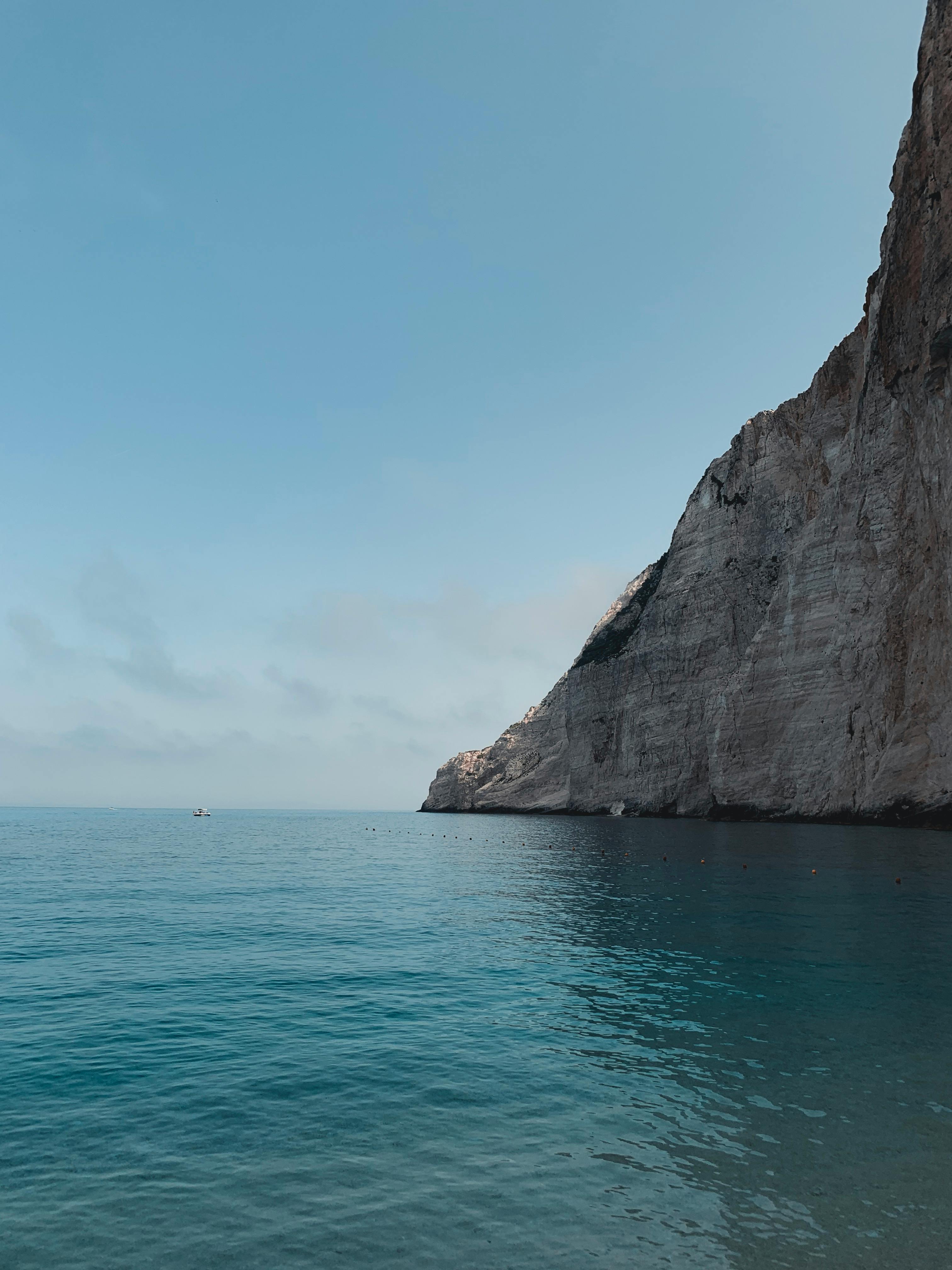 夏季日落时分，宁静的海面与平静的海水，映衬着令人惊叹的悬崖背景