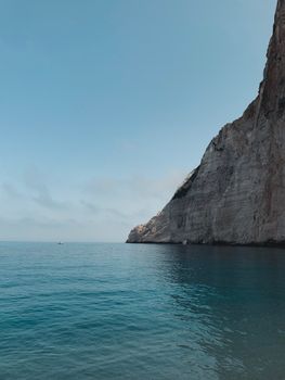 夏季日落时分，宁静的海面与平静的海水，映衬着令人惊叹的悬崖背景