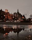 雨后，城市街景的灯光和建筑物倒映在水坑中