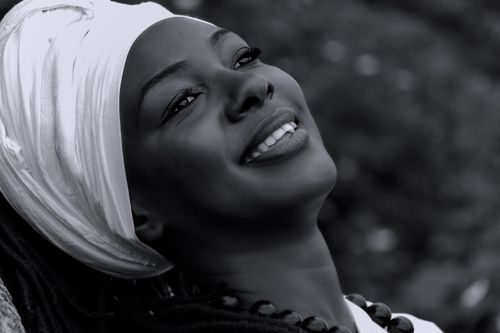 Free Captivating monochrome portrait of a woman with a turban, smiling contentedly outdoors. Stock Photo