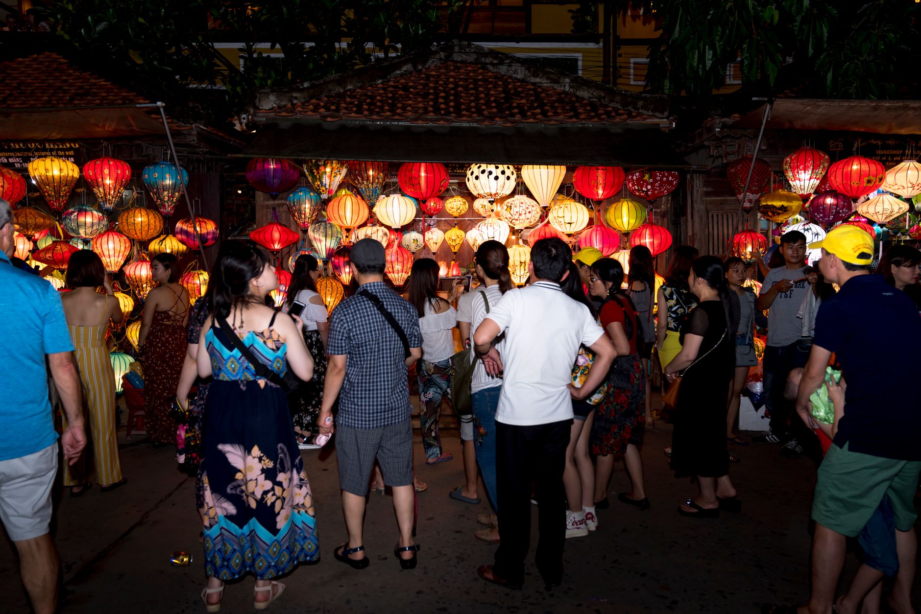 Colorful lantern festival with crowds gathered at night market street, creating a lively and festive atmosphere.