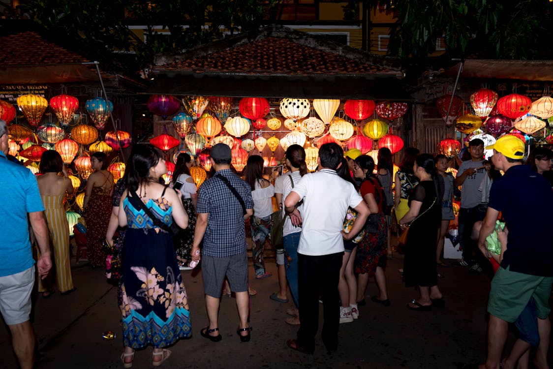 Photo of People Standing Near Lighted Lanterns