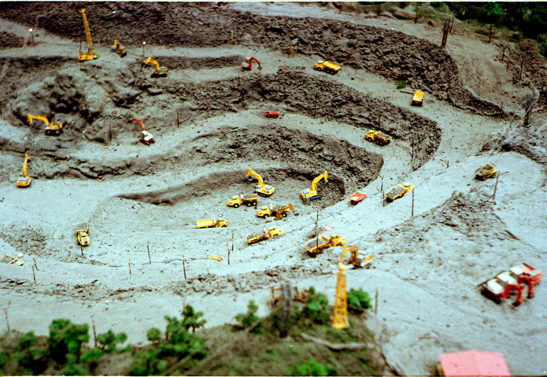 Aerial shot of a toy construction site with miniature bulldozers and excavators.