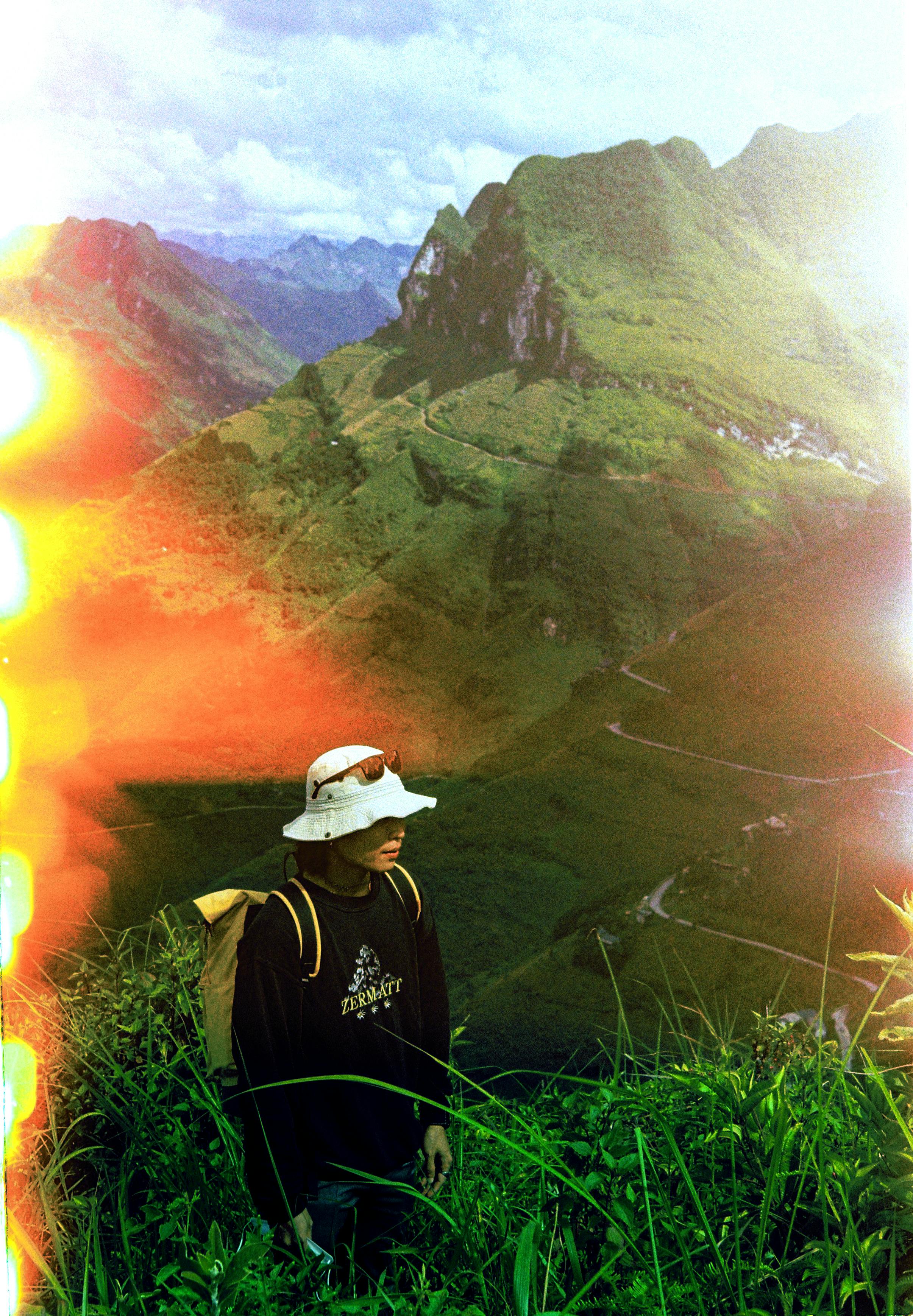 A person enjoys a scenic mountain view under vibrant sky.