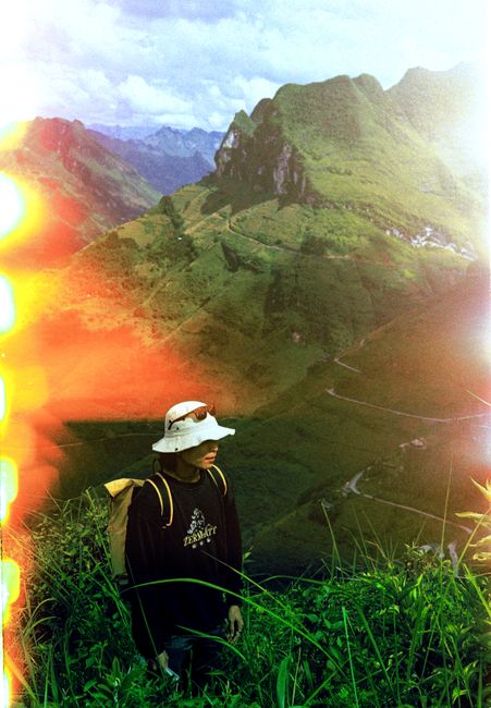 A person enjoys a scenic mountain view under vibrant sky.