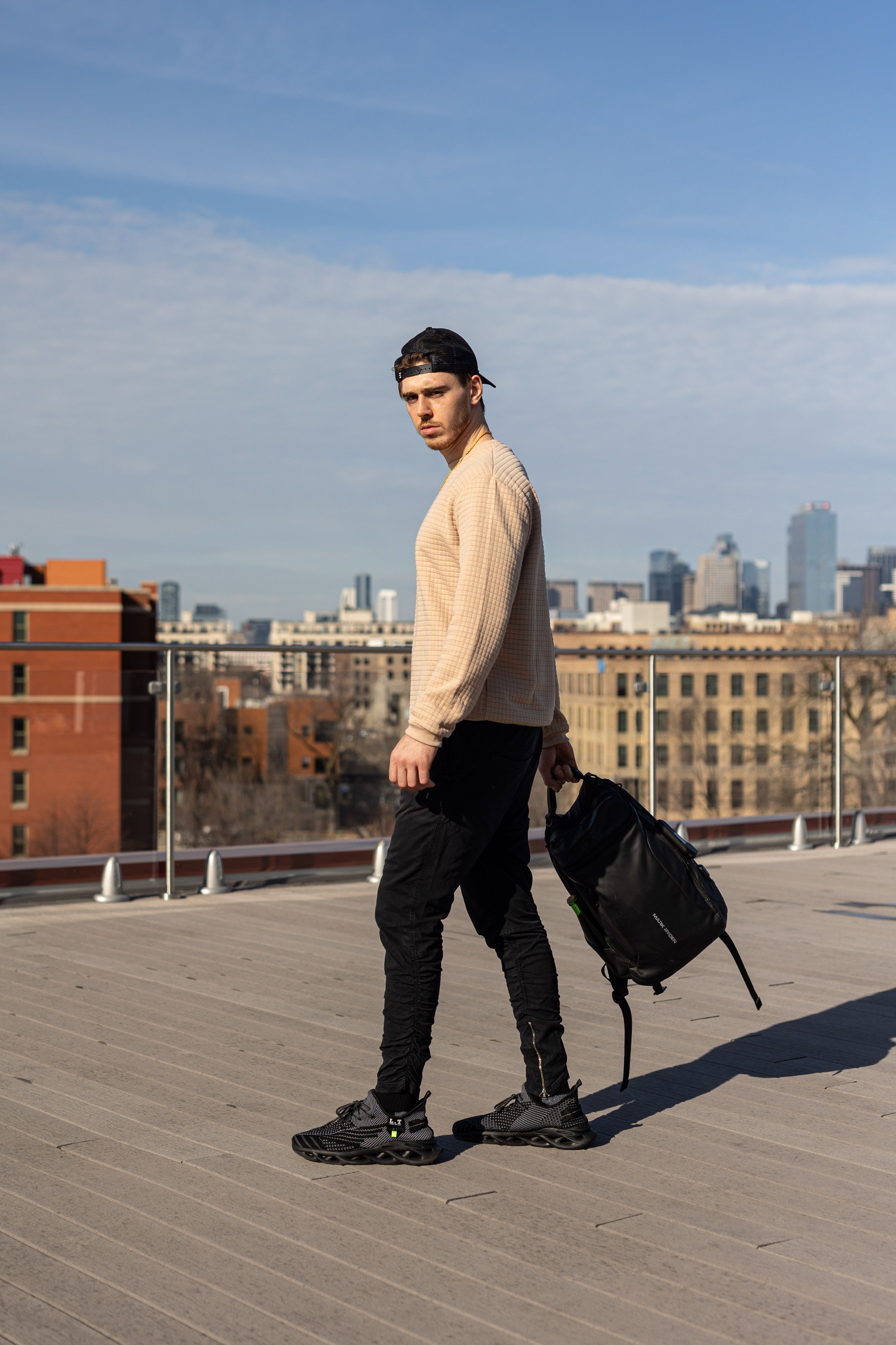 A Young Man in Fashionable Clothes Posing on a Terrace · Free Stock Photo