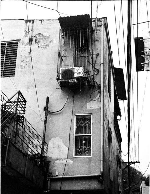 Free Black and white photo showcasing an old building with rust and exposed wires, exuding vintage urban decay. Stock Photo
