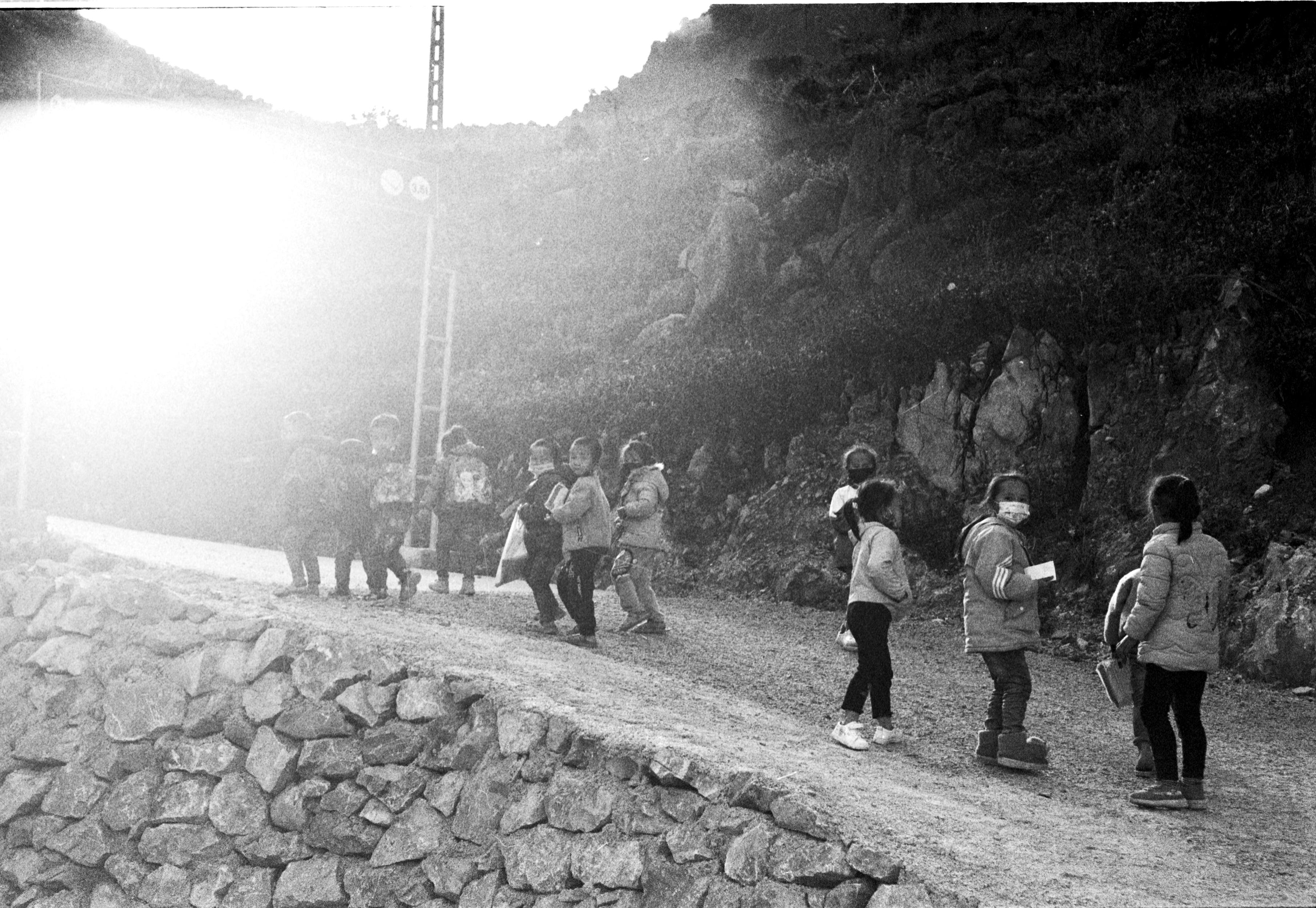 Bright morning sunlight over the hills of Ho Ghana with people walking toward a modern church building