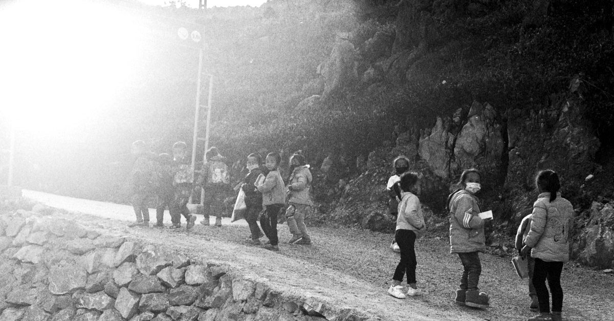 Bright morning sunlight over the hills of Ho Ghana with people walking toward a modern church building