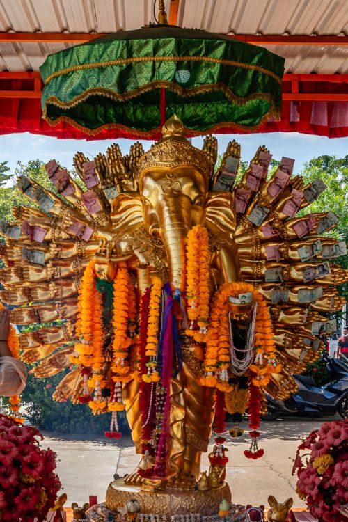 Free A vibrant golden Ganesha statue adorned with colorful garlands in Bangkok, Thailand. Stock Photo