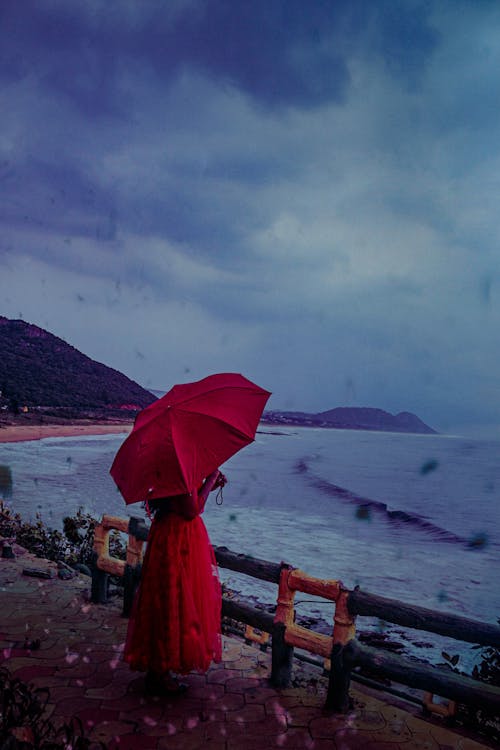 빨간 우산을 들고 빨간 드레스를 입고 사람의 사진