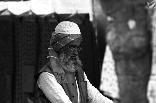 Free Black and white portrait of an elderly man wearing traditional Indian clothing, gazing down thoughtfully. Stock Photo