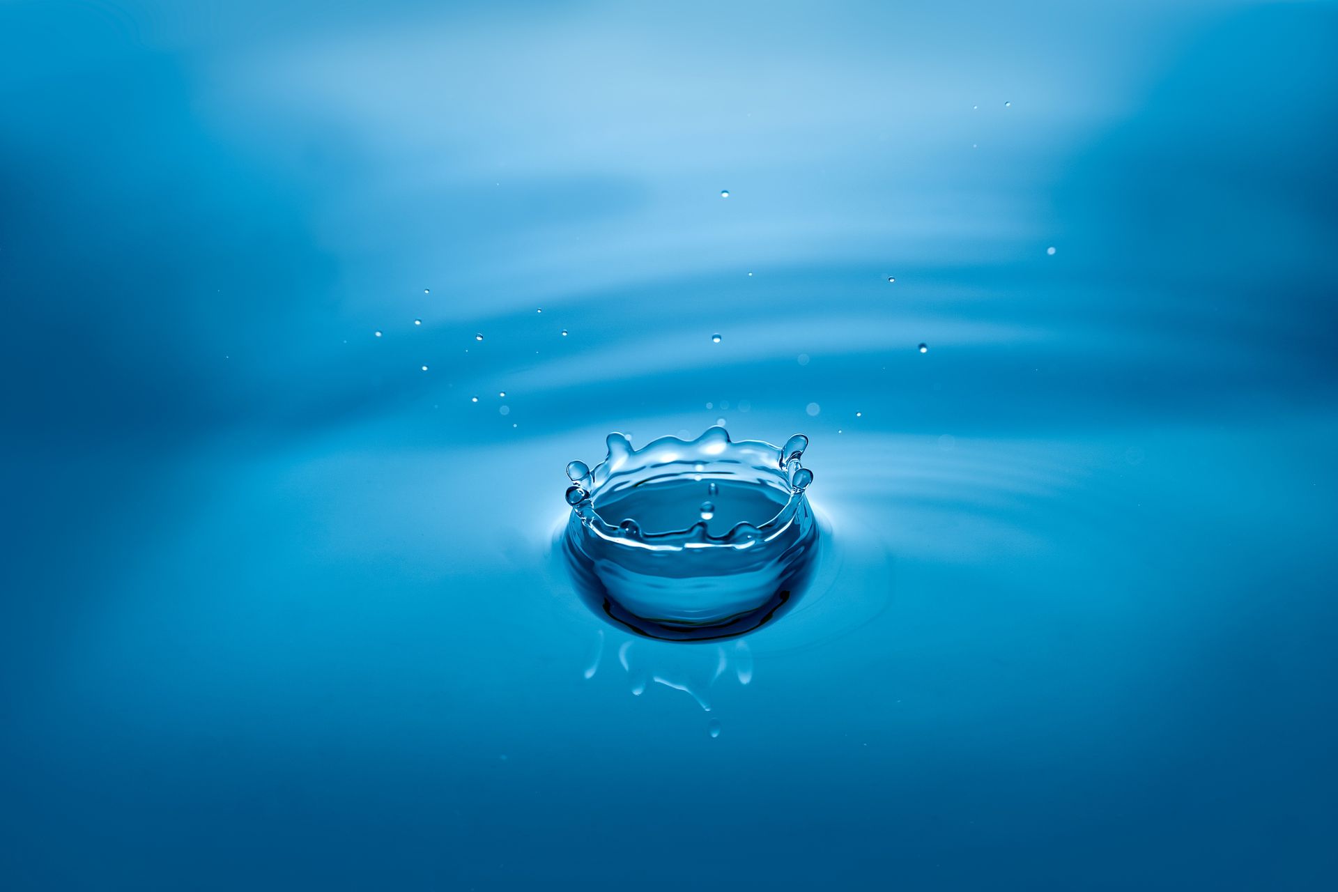 Blue water droplet creating ripples