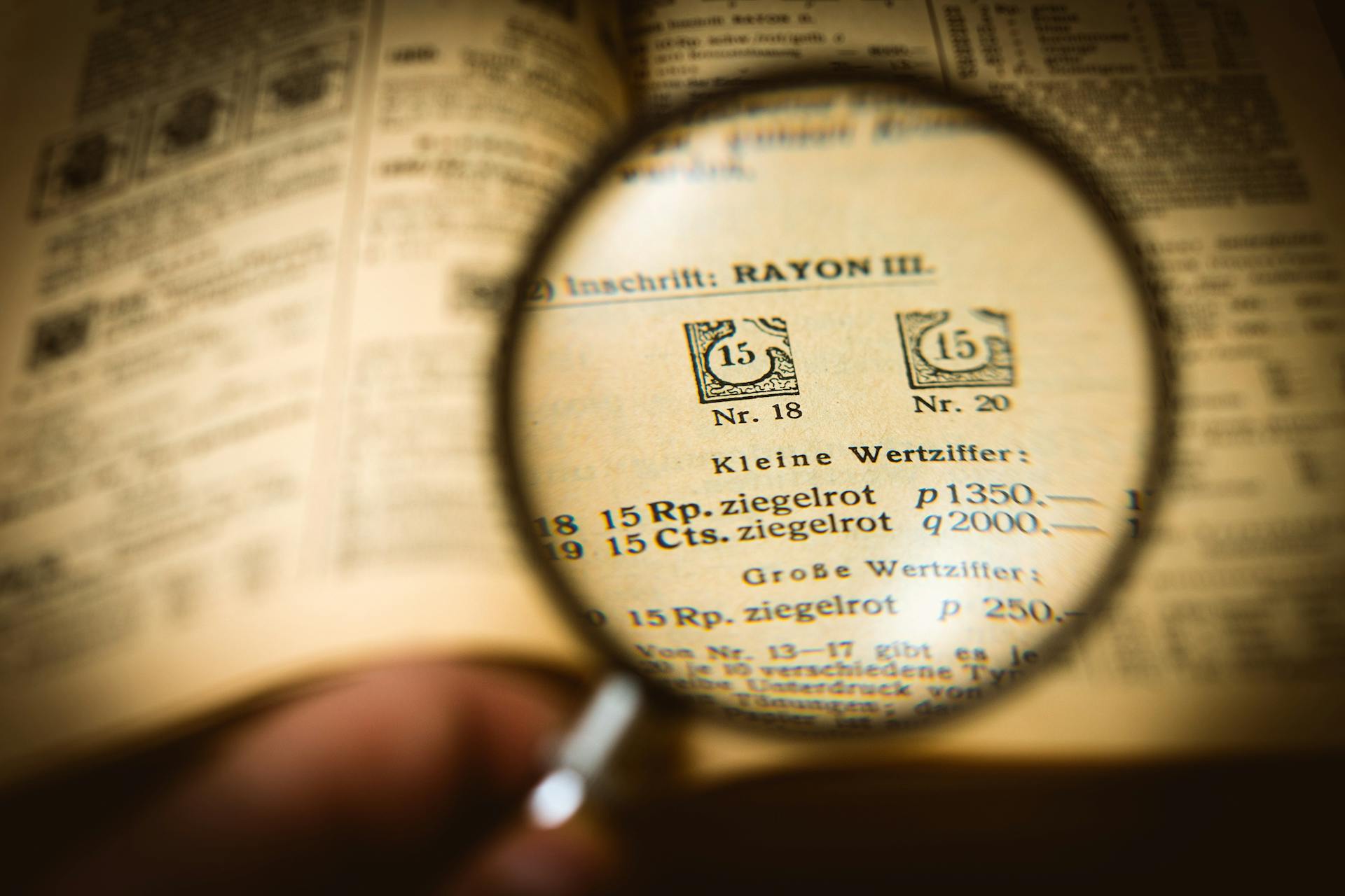 Detailed view of a book page magnified by a glass, enhancing text clarity.