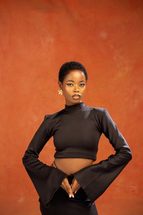 A woman in black top and skirt posing for the camera