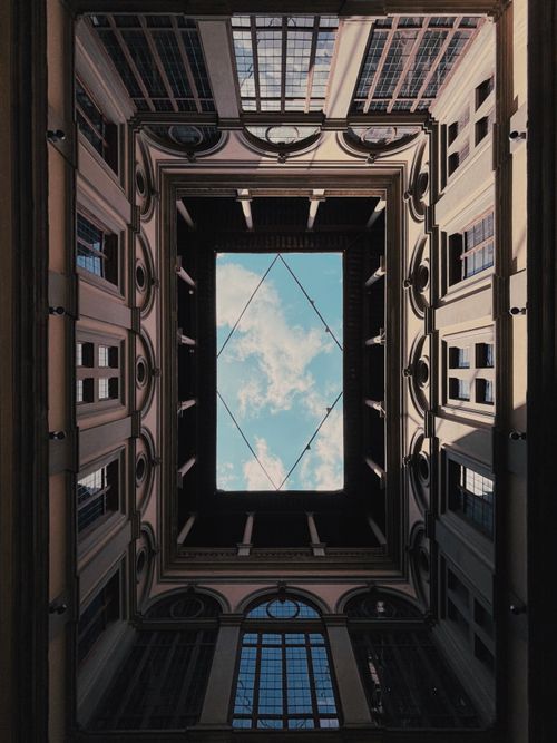 Free Capture of the sky framed by historic architecture in Palazzo Strozzi, Florence, Italy. Stock Photo