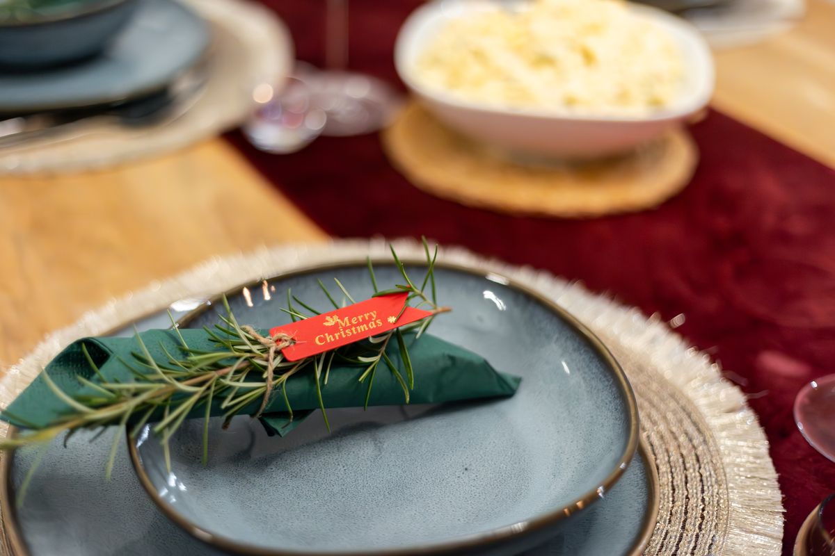 Pocket-folded napkin on a Christmas plate tucked with a green sprig