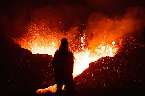 A person standing in front of a large lava flow