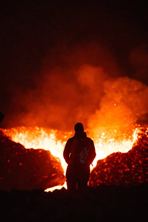 A man stands in front of a lava flow