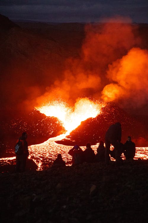People are gathered around a large lava flow