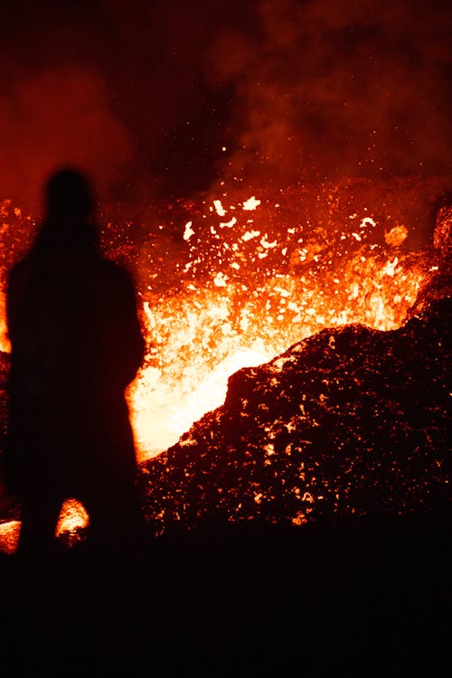 A person standing in front of a fire with lava