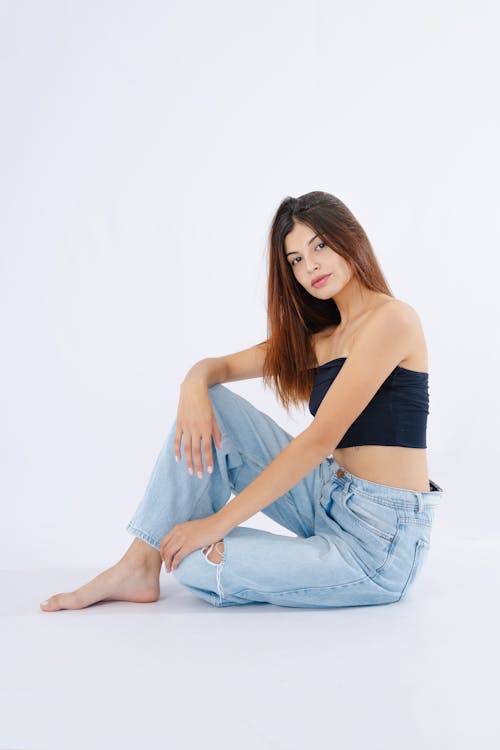 A woman sitting on the floor in jeans