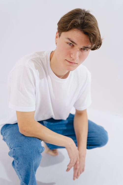 A young man in a white t - shirt and jeans