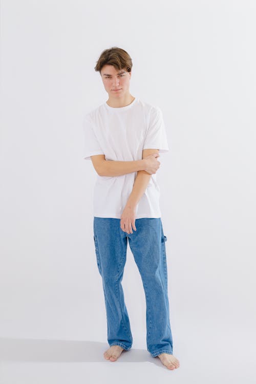 A young man in white t - shirt and blue jeans