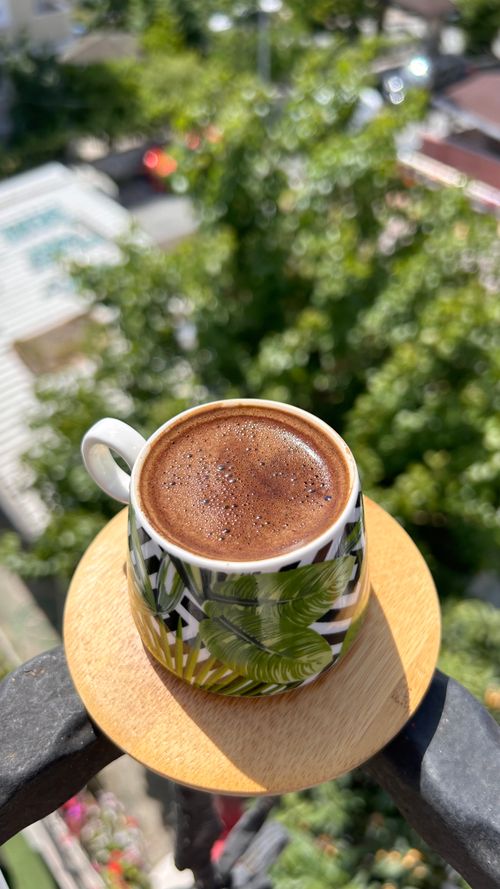 Free A warm cup of coffee on a balcony with a lush, green view, perfect for relaxation. Stock Photo