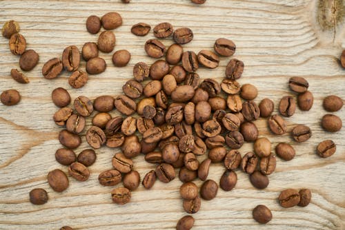 在木質表面上的咖啡豆平躺攝影