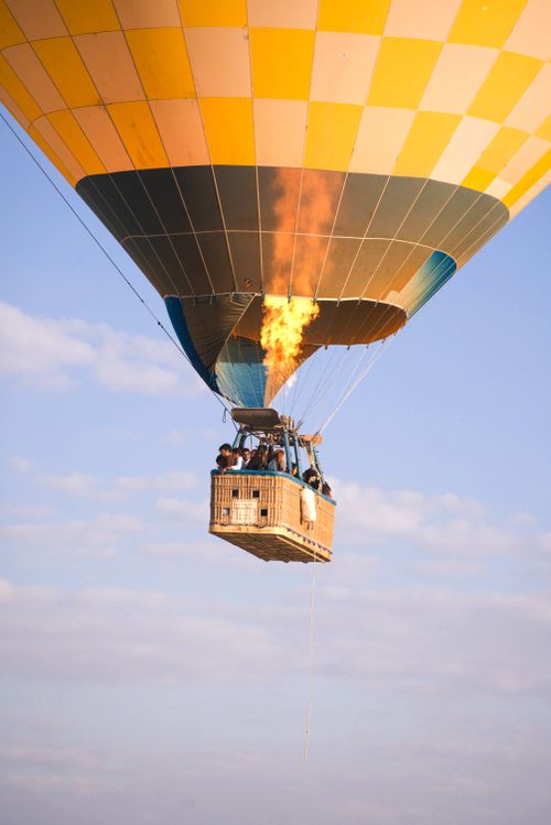 Free Vibrant hot air balloon soaring above with scenic views and blue sky. Stock Photo