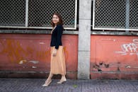 一名亚洲妇女自信地走过城市环境中涂鸦覆盖的墙壁