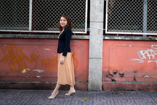 一名亚洲妇女自信地走过城市环境中涂鸦覆盖的墙壁