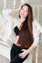 一位优雅的年轻女子在室内摆姿势，长发飘逸，衣着时髦
