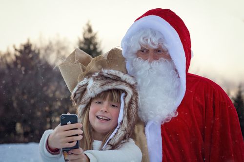 Free A young girl takes a selfie with Santa Claus in a snowy outdoors setting. Stock Photo