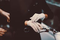 一位戴着蕾丝手套的女人手持老式自行车车把，显得十分优雅