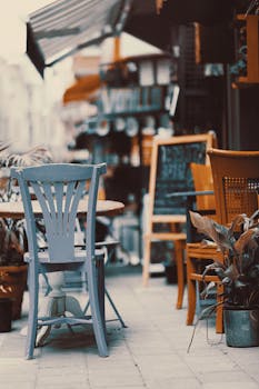 Cozy outdoor cafe with vintage chairs and tables on a sunny street. Perfect spot to relax.
