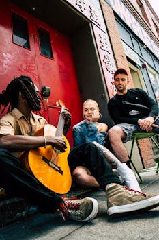 一群不同的音乐家带着吉他和附近的朋友在街上表演