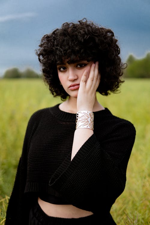 A woman with curly hair in a field