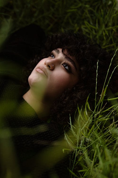 A woman laying in the grass with her eyes closed