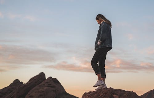 Free Low Angle Side View Photo of Woman Standing on Rock Stock Photo