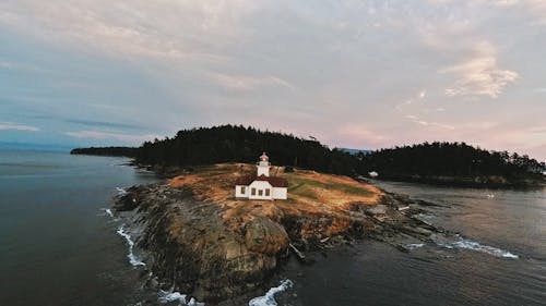 Free White and Brown Lighthouse Near Body of Water Stock Photo